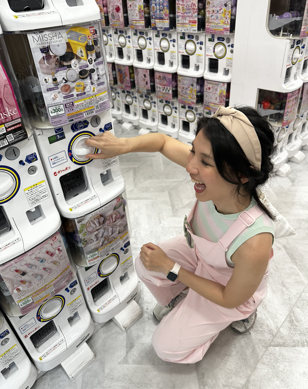 Zee happily turning a gachapon machine in Japan